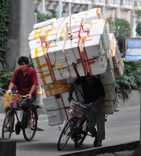 Trabalhador com bicicleta lotada de pacotes na China